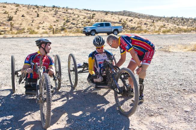 From left, Kevin Dubois, Tim Brown, and Jim Penseyres discuss the performance of the 3-wheel hand-powered mountain bikes, built by Bill Lasher of Las Vegas, after one of the rides during Ride 2 Recovery's Las Vegas Mountain Bike Challenge Monday, Jan. 27, 2014. Dubois, Brown and Penseyres are USMC Veterans who have been wounded in combat. Dubois and Brown were injured in 2011 by Improvised Explosive Devices during their deployments to Afghanistan, while Penseyres lost his leg below the knee after stepping on a land mine during his rotation to Vietnam in 1968. Penseyres is now the National Training Coach for Ride 2 Recovery, a nonprofit organization that provides rehabilitation to injured veterans through cycling.